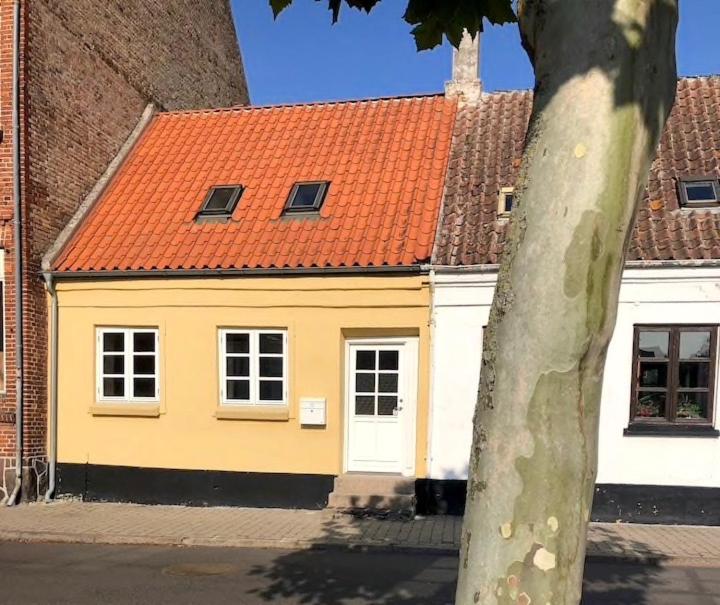 a yellow house with an orange roof at Torvet 19 - Maribo in Maribo