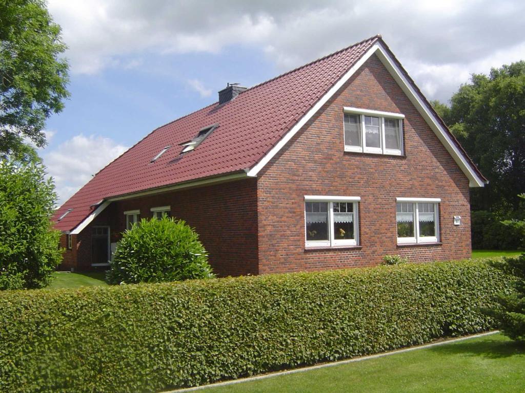 a brick house with a red roof at Ferienwohnung Landleben 35195 in Hesel