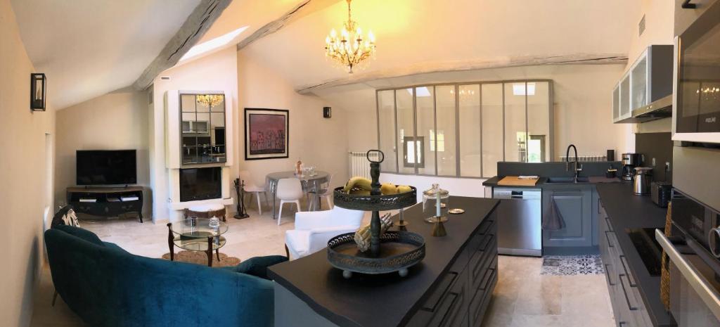 una cucina e un soggiorno con tavolo e sedie di La Bri...Gite a LʼIsle-sur-la-Sorgue