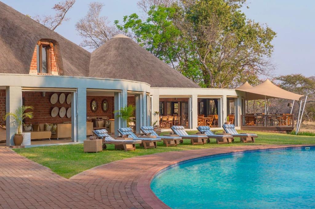 a resort with a swimming pool in front of a house at Lilayi Lodge in Lusaka