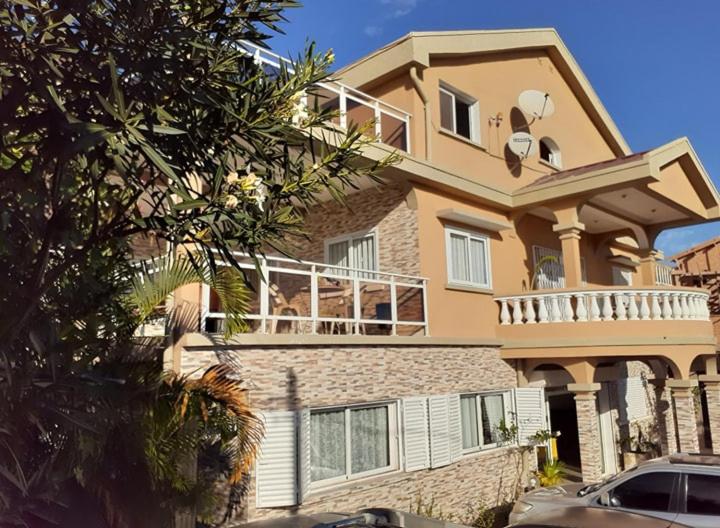 a large house with a balcony on top of it at K.méléon-Hôtel in Ivato