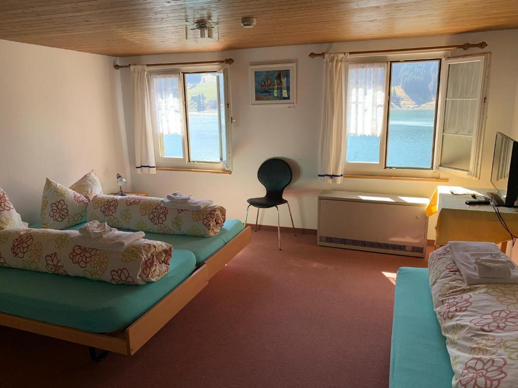 ein Wohnzimmer mit einem Sofa, einem Tisch und Fenstern in der Unterkunft Fischers Lodge in Innerthal