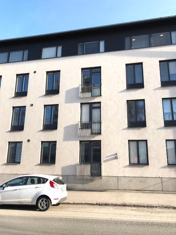 a white car parked in front of a building at Vaasa Apartments 4 in Vaasa