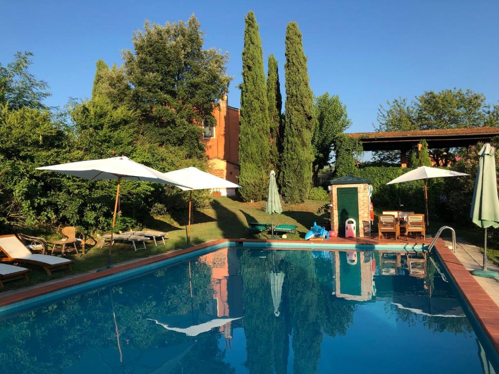 uma piscina com guarda-sóis, mesas e cadeiras em Agriturismo Podere Marchiano em Larciano