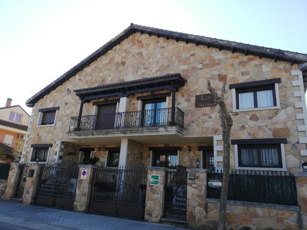 a stone building with a balcony on the side of it at Los Alisos Casa Rural in Guadalix de la Sierra