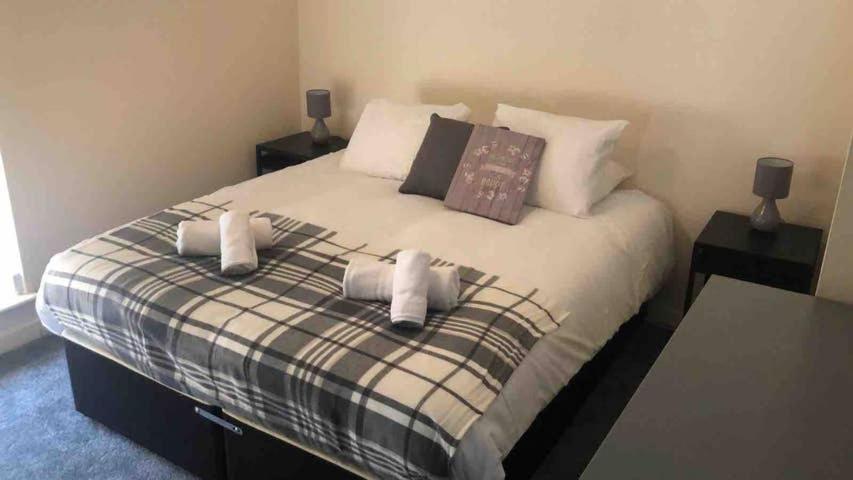 a bedroom with a bed with two pillows on it at Comfy Stays Swansea in Swansea