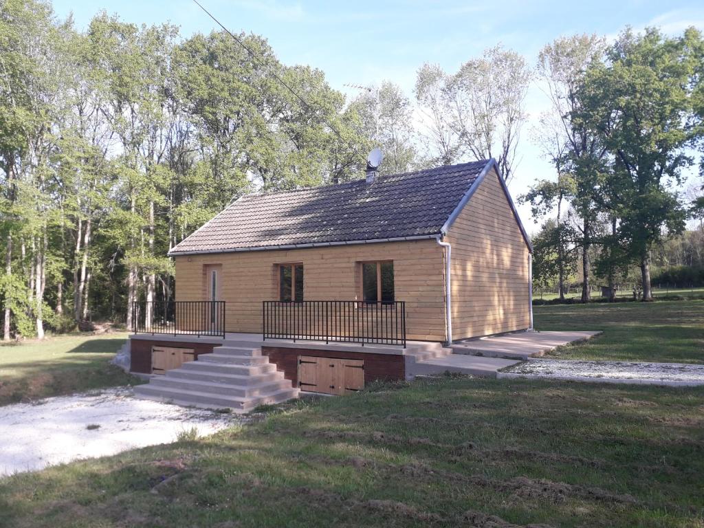 ein kleines Haus mit einer Veranda und einer Treppe auf einem Feld in der Unterkunft maison indépendante in Saint-Amand-en-Puisaye