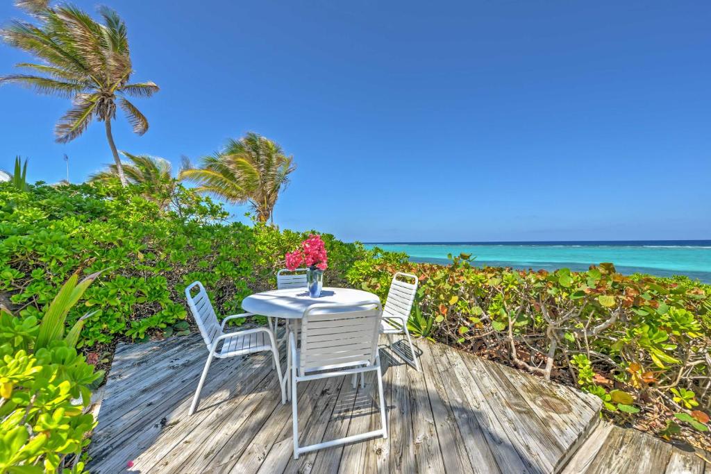 stół z dwoma krzesłami i wazon z kwiatami w obiekcie Northside Grand Cayman Getaway with Private Beach! w mieście North Side