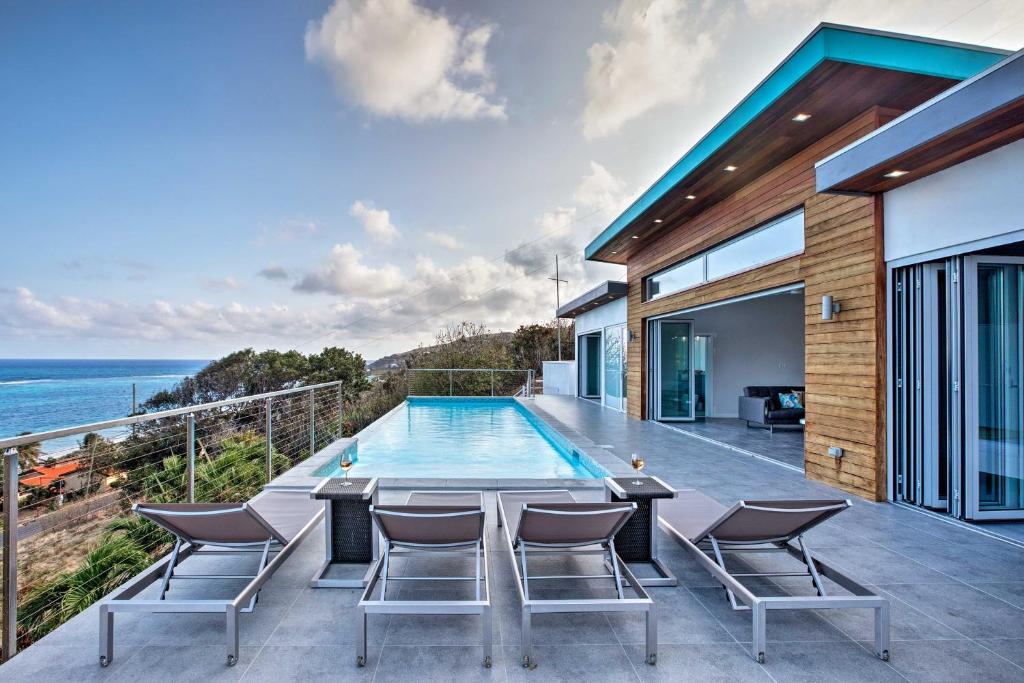 a house with a swimming pool and the ocean at Luxury St Croix Home with Oceanfront Pool and Views in Slob