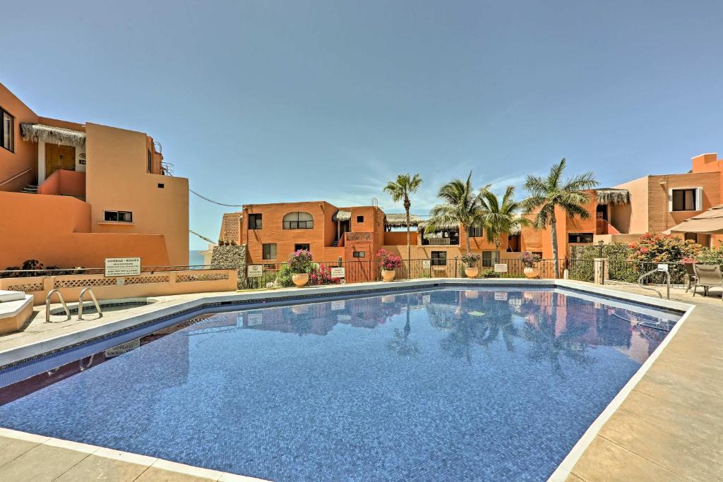 a large swimming pool in front of a building at Cabo Condo with Balcony, Ocean Views and Resort Perks! in Cabo San Lucas