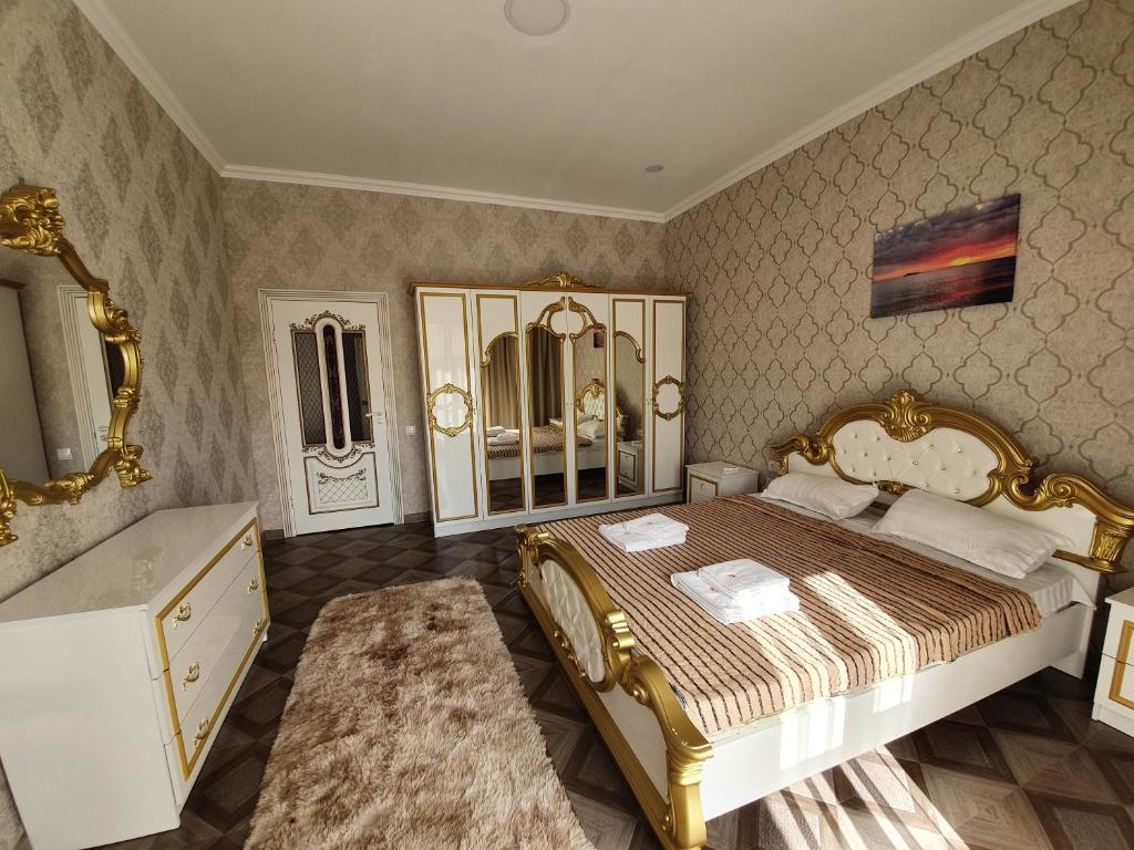 um quarto com uma cama dourada e um lavatório em Инжу Алаколь em Qabanbay