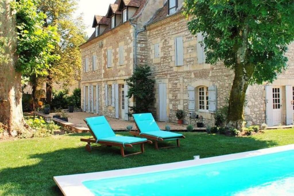 2 sillas y una piscina frente a una casa en Manoir du Bois Mignon Luxury Home - Dordogne en Le Fleix