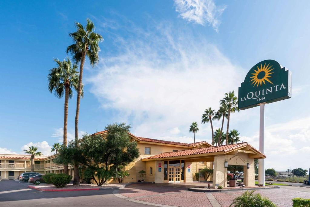 a large palm tree in front of a hotel at La Quinta Inn by Wyndham Phoenix Thomas Road in Phoenix
