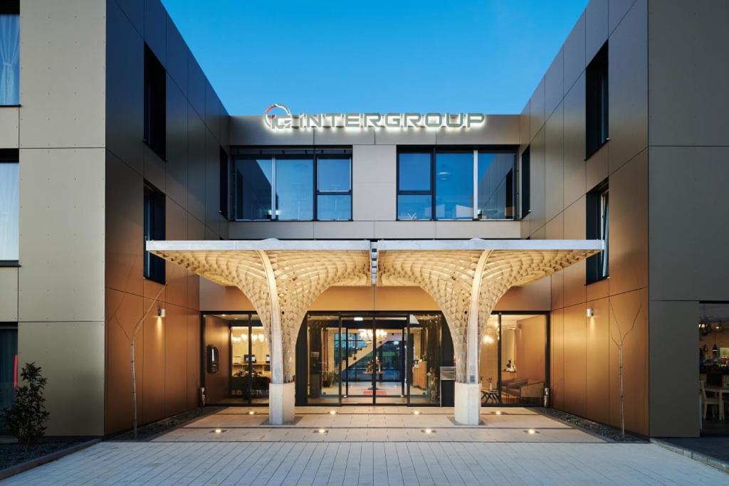einem externen Blick auf ein Gebäude mit einem großen Eingang in der Unterkunft Intergroup Business & Design Hotel Ingolstadt in Kösching