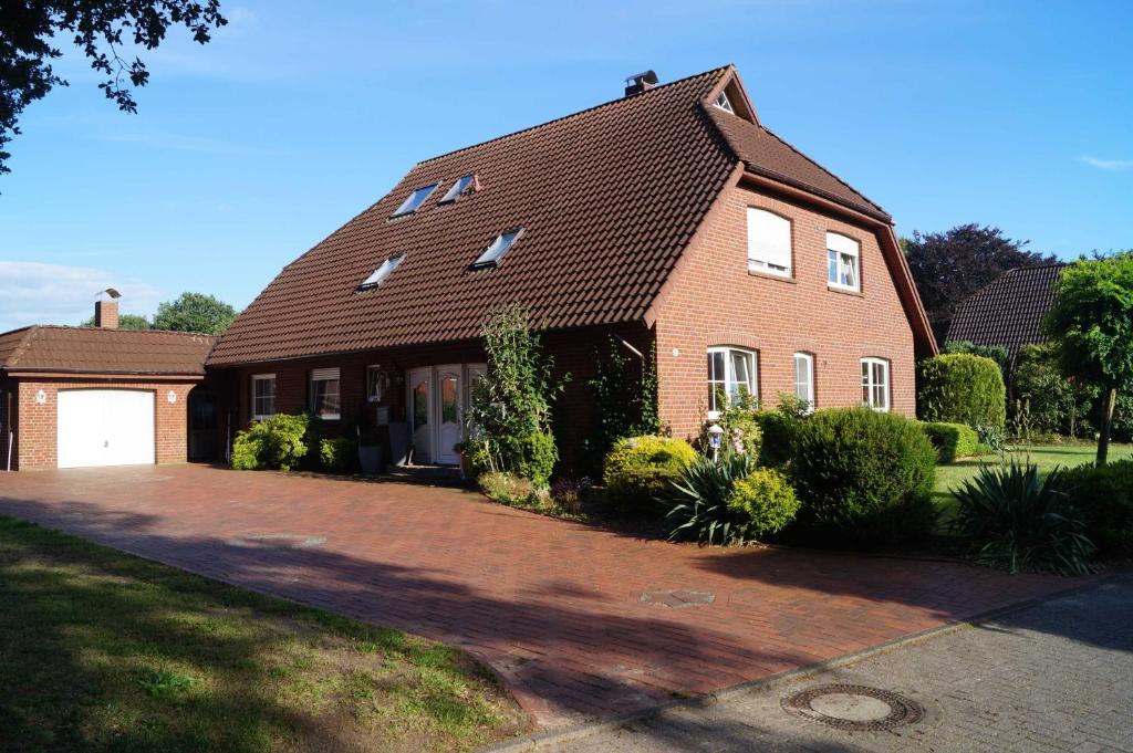 a brick house with a driveway in front of it at Ferienwohnung Hooge Loogen, 35212 in Holtland