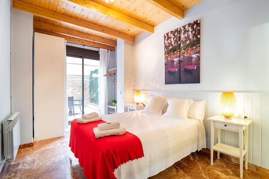 Un dormitorio con una cama blanca con una manta roja. en Spacious Sagrada Familia By MyRentalHost, en Barcelona