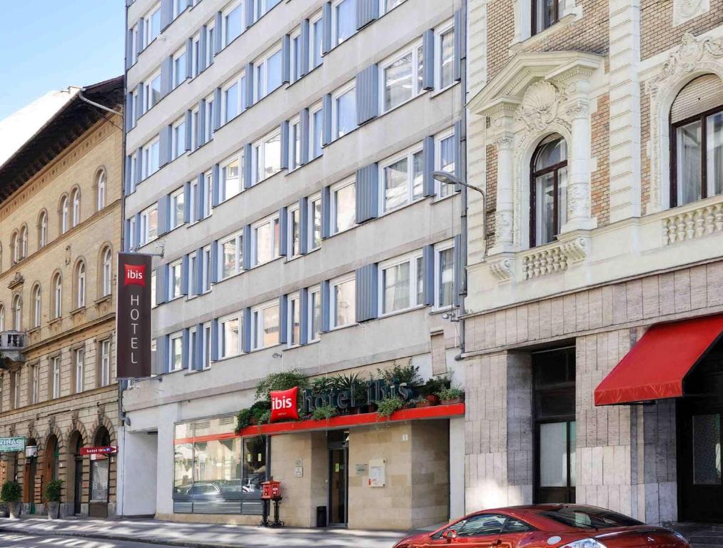 un coche rojo estacionado frente a un edificio en Ibis Budapest City en Budapest