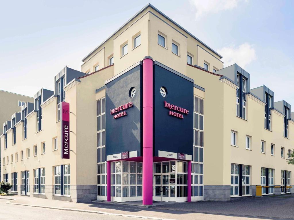 ein großes Gebäude mit einem großen Schild auf der Vorderseite in der Unterkunft Mercure Hotel Würzburg am Mainufer in Würzburg