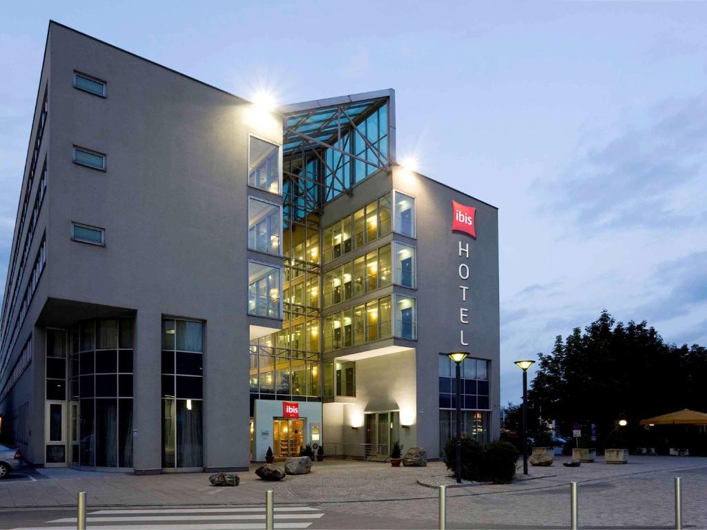 a large building with a sign on the front of it at Ibis Linz City in Linz