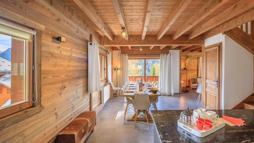 a dining room with wooden walls and a table at Les Montagnards - Chalet - BO Immobilier in Châtel
