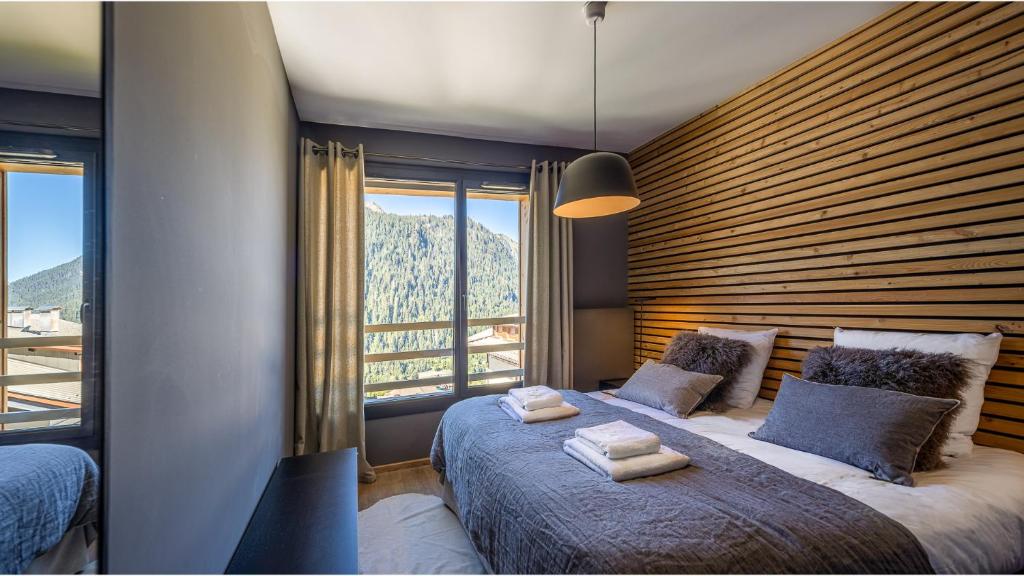 une chambre avec un grand lit et une grande fenêtre dans l'établissement The View - Apt 06 - BO Immobilier- Châtel - Châtel Multipass Été 2025 en option au tarif de 3euros par jour et par personne, à Châtel