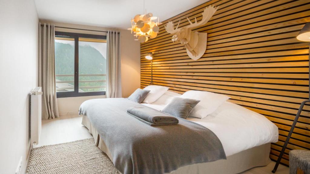 1 dormitorio con cama grande y ventana grande en Les 360 - Apt 15 - BO Immobilier en Châtel