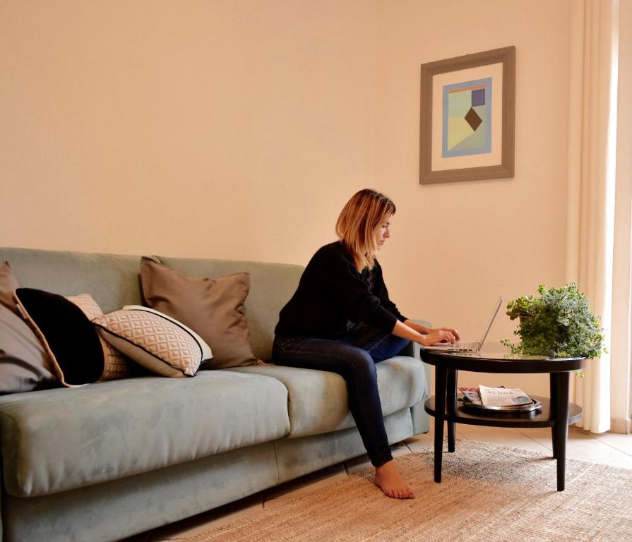 a woman sitting on a couch using a laptop at Spacebility Expo in Cagliari