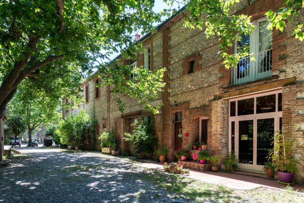 une rue vide devant un bâtiment en briques dans l'établissement Domaine du Mas Bazan, à Alénya