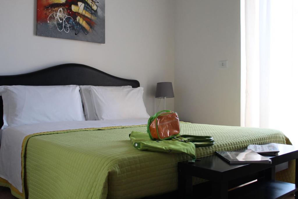 オージモにあるHotel La Ruota Dei Pavoniのベッド(緑の毛布、袋付)