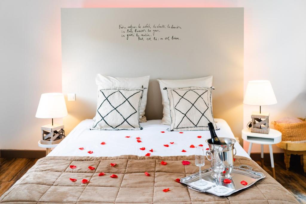 a bedroom with a bed with red roses on it at La Maison Gustave in Narbonne