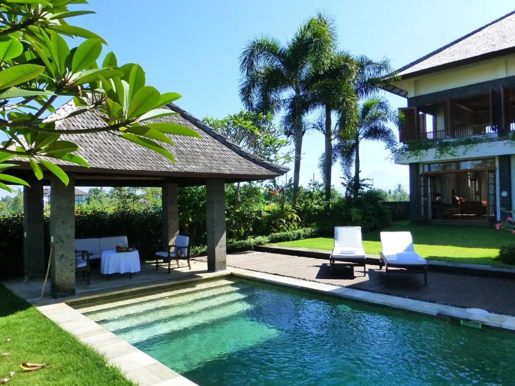 a swimming pool in front of a villa at Villa Kawan in Tanah Lot