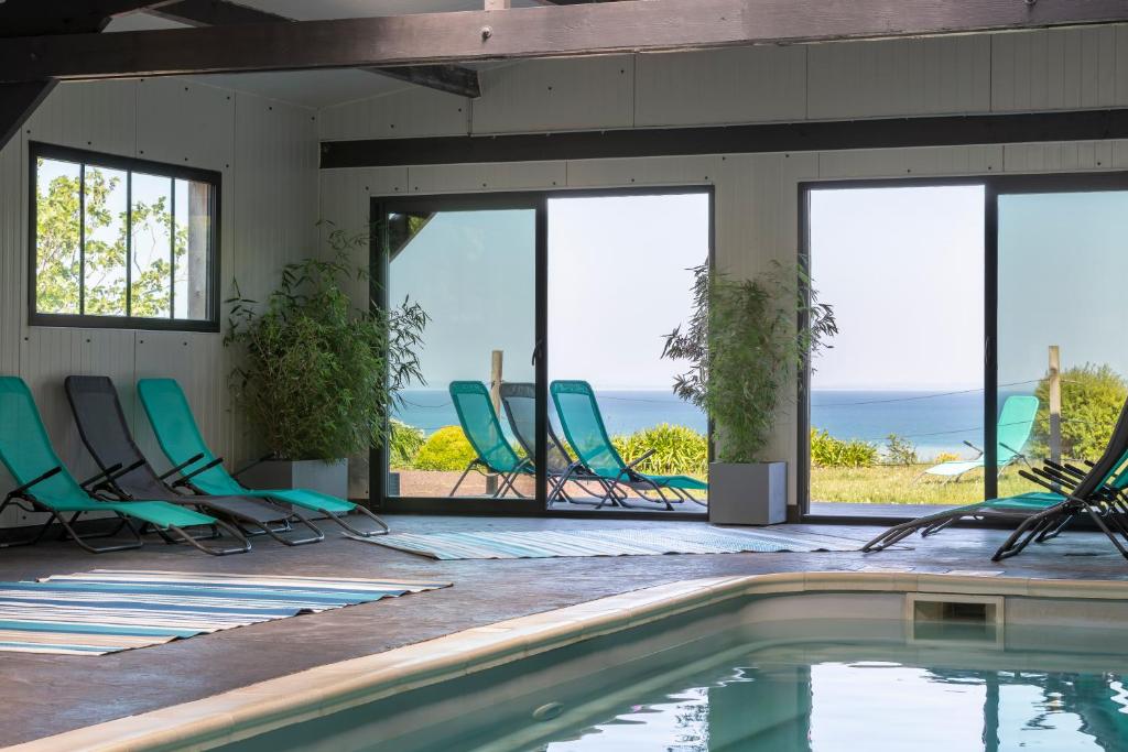 une maison avec une piscine et des chaises dans l'établissement La Metairie-du-Vauhariot - Lodge ou Chambre - Piscine Chauffée - Vue Mer et Mont Saint Michel - GR34 - Résidence Hôtelière, à Cancale