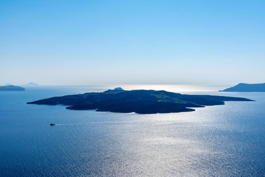 an island in the middle of the water at Adamant Suites in Fira