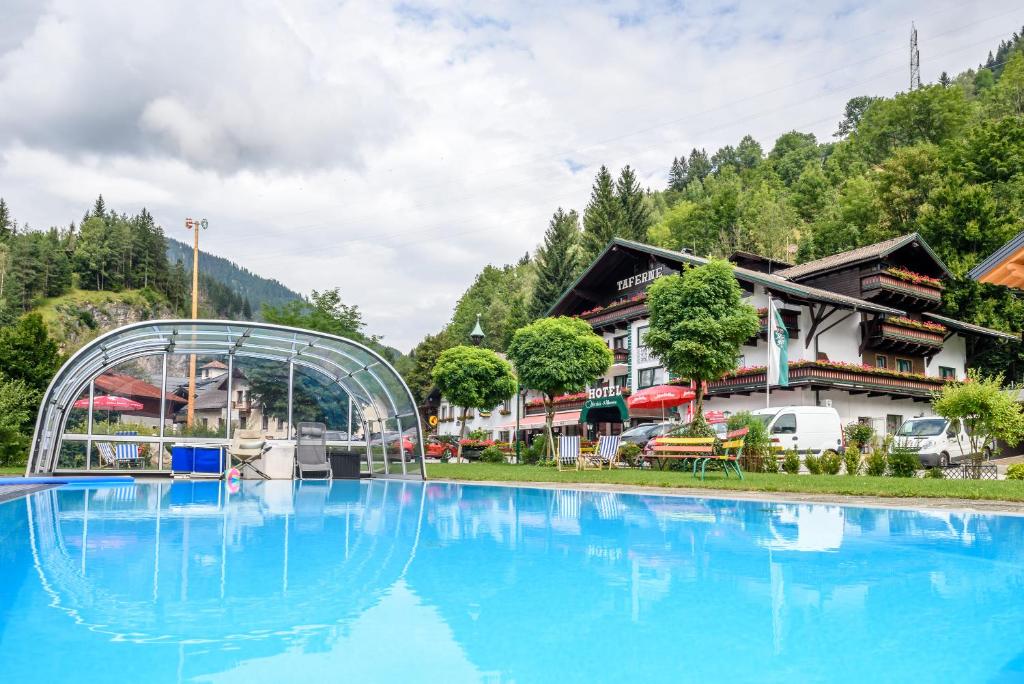 a large swimming pool in front of a resort at Hotel & Gasthof Taferne in Schladming