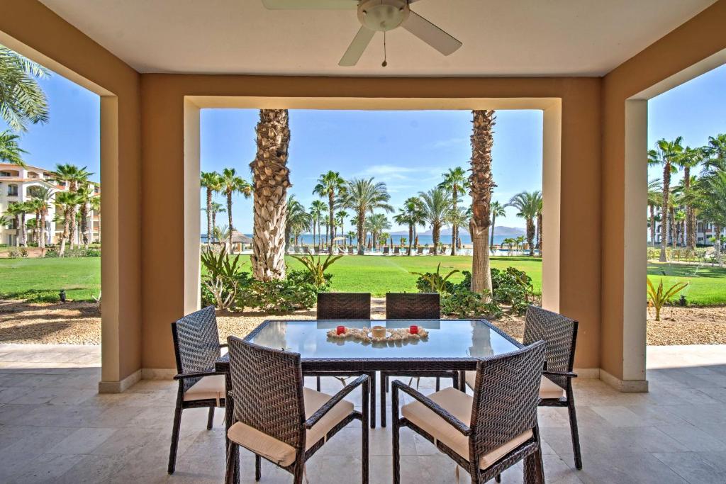 a dining room with a table and chairs and palm trees at Paraiso del Mar Resort Condo Water Taxi to La Paz in La Paz