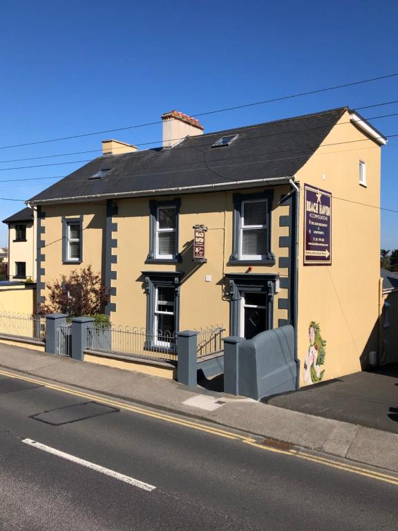 un edificio amarillo al lado de una calle en Beach Haven Apartments, en Tramore