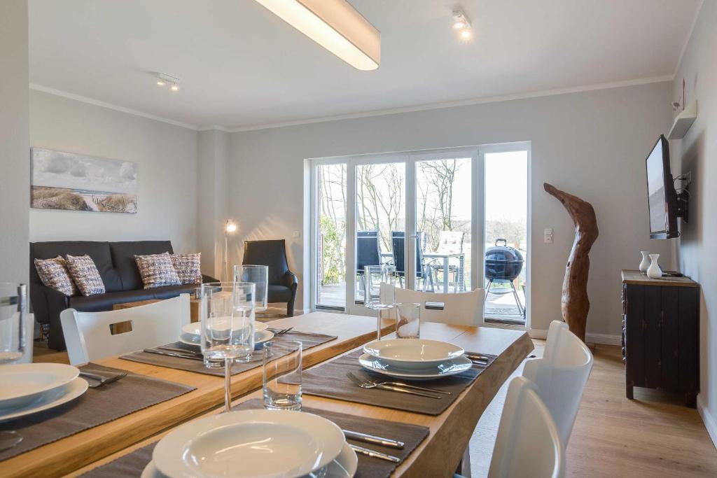 a dining room and living room with a table and chairs at Fehmarn in List