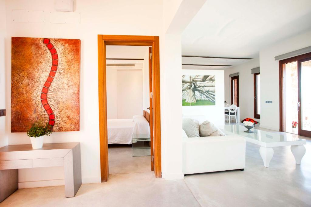 a living room with a white couch and a glass table at Casa Romero in Cala Saona