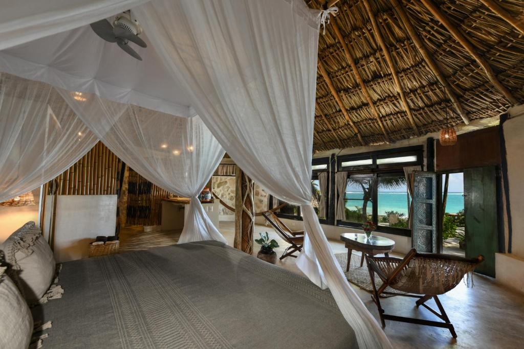 a bedroom with a bed with curtains and a table at Diamante K - Inside Tulum National Park in Tulum