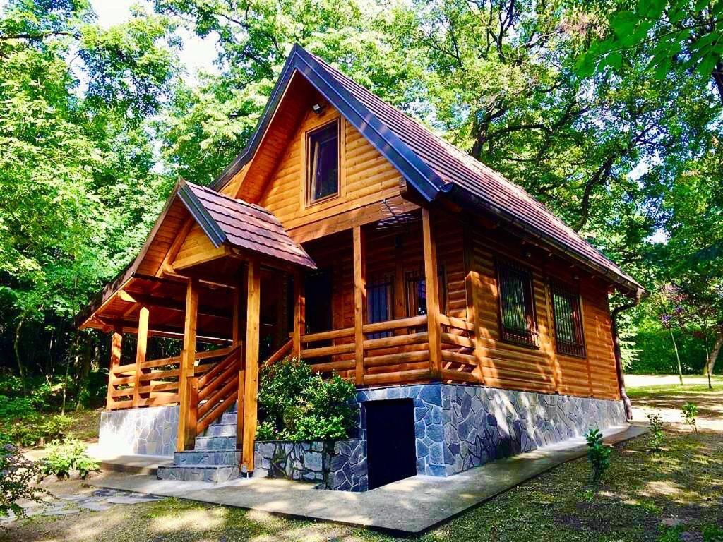 a log cabin with a porch and a door at Brvnara Vršac in Vršac