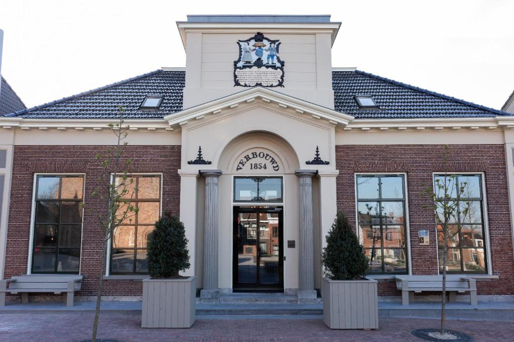 een gebouw met een klok erop bij Hotel de ABDIJ Dokkum in Dokkum