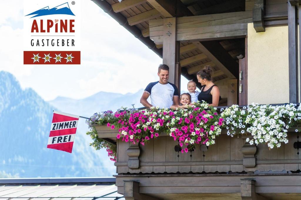 a group of people standing on a balcony with flowers at Gästehaus Stotter in Neukirchen am Großvenediger