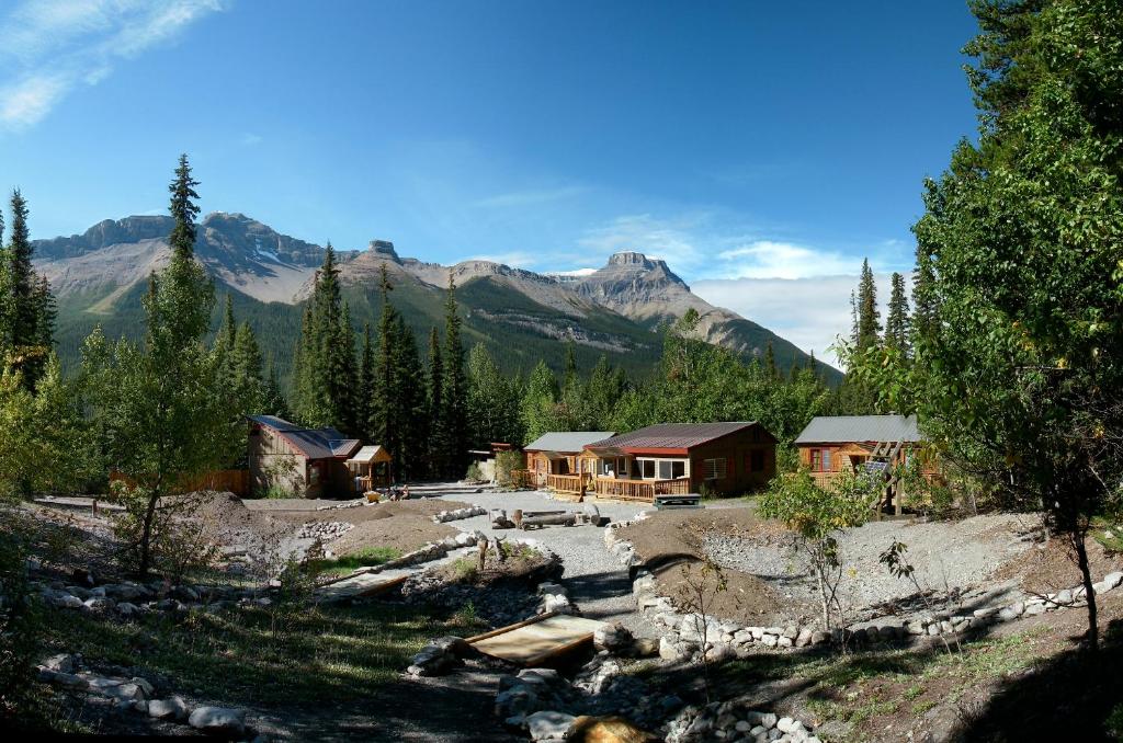 um grupo de cabanas com montanhas ao fundo em HI Rampart Creek - Hostel em Saskatchewan River Crossing