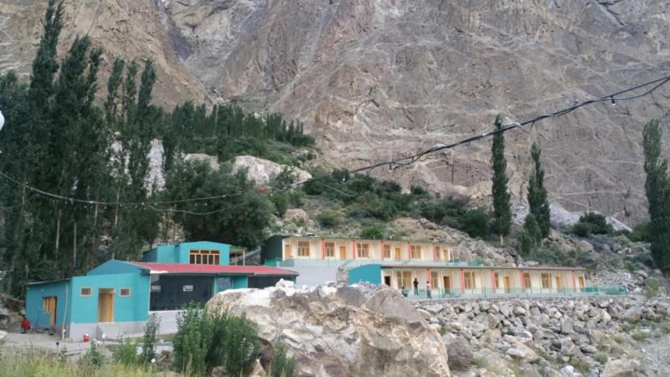 a building on a hill with a mountain in the background at Eden Lake View Hotel in Baltit