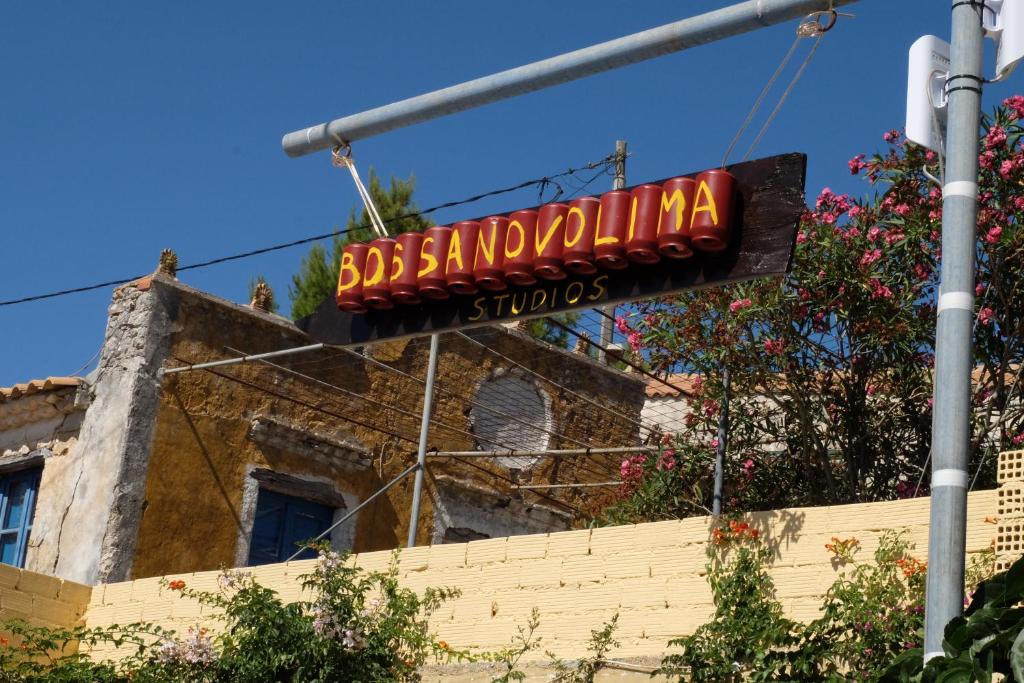 a sign for a restaurant on the side of a building at Bossanovolima studios in Volimes