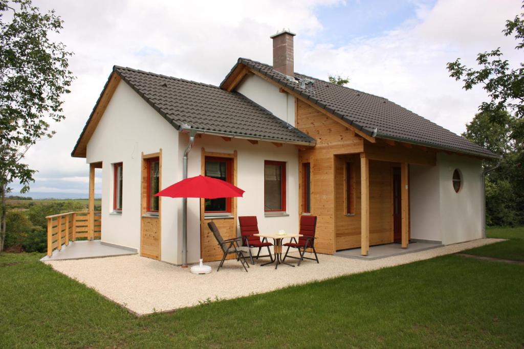 une petite maison avec une table et des chaises dans l'établissement Robiniapark, à Szólád