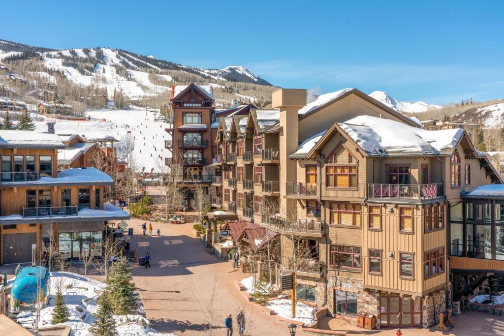 an aerial view of a resort with snow covered mountains at Capitol Peak Lodge by Snowmass Mountain Lodging in Snowmass Village