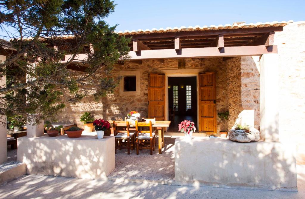 a house with a table and chairs in front of it at Casa Piedra in Cala Saona
