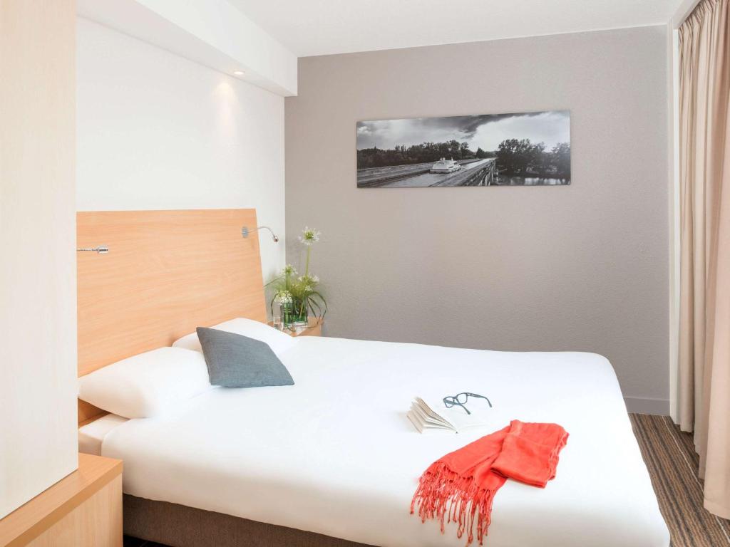 Una cama o camas en una habitación de Aparthotel Adagio Toulouse Centre Ramblas