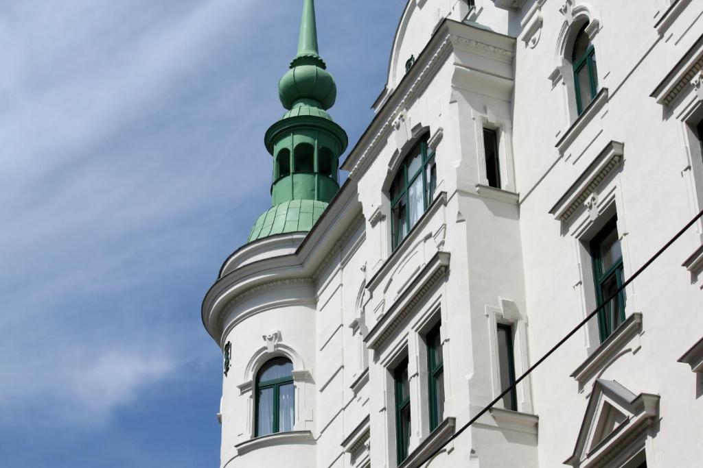 ein grüner Turm auf einem weißen Gebäude in der Unterkunft Hotel-Pension Wild in Wien